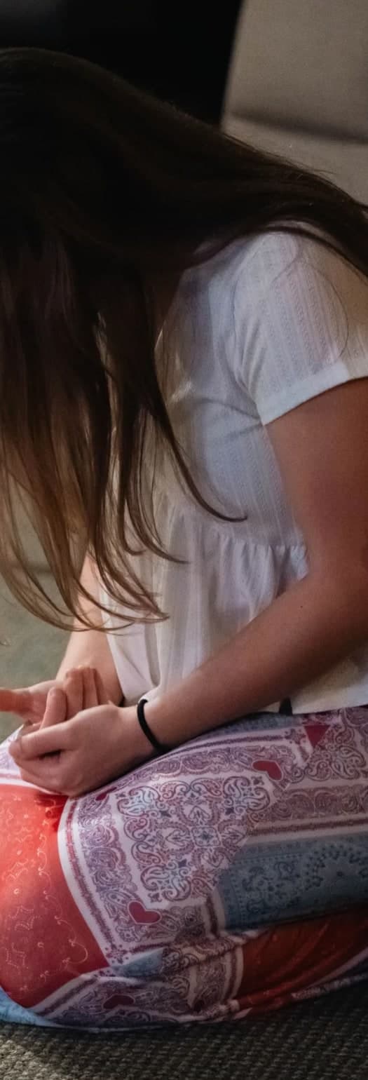 A woman kneeling in prayer, from the photography on Victory Church’s website.